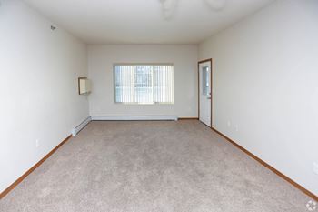A bedroom with white walls and carpet